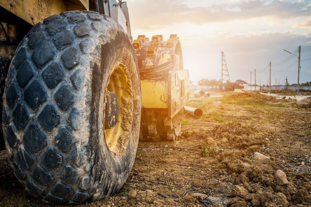 A Large Tire is on the Ground Next to a Bulldozer — JTM Projects Australia Pty Ltd in Port Hedland, WA