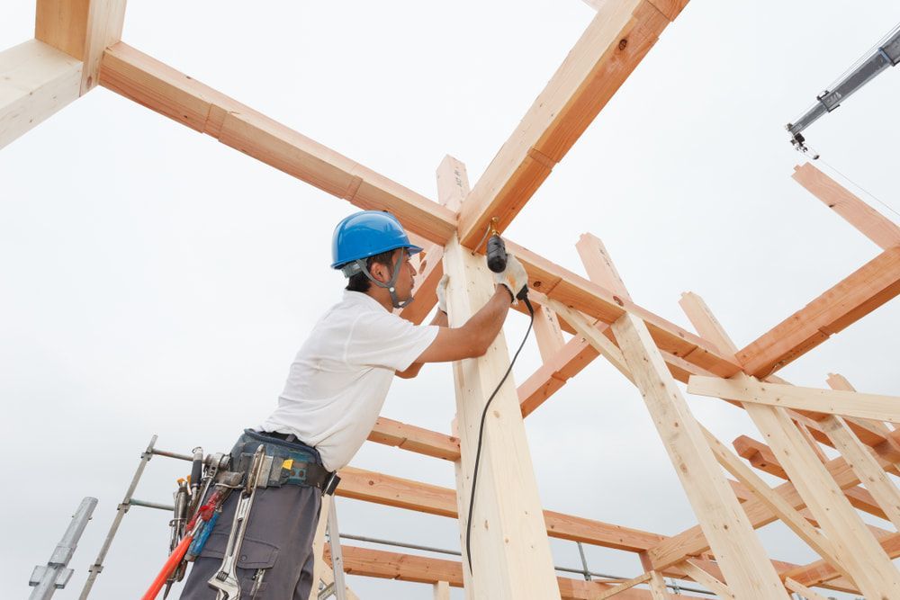A Construction Worker Is Working On A Wooden Structure — JTM Projects Australia Pty Ltd in Mackay, QLD