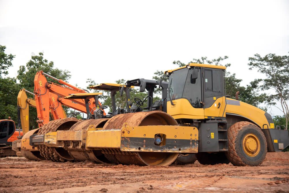 A Yellow and Black Construction Vehicle is Parked in a Dirt Field — JTM Projects Australia Pty Ltd in Gold Coast, QLD