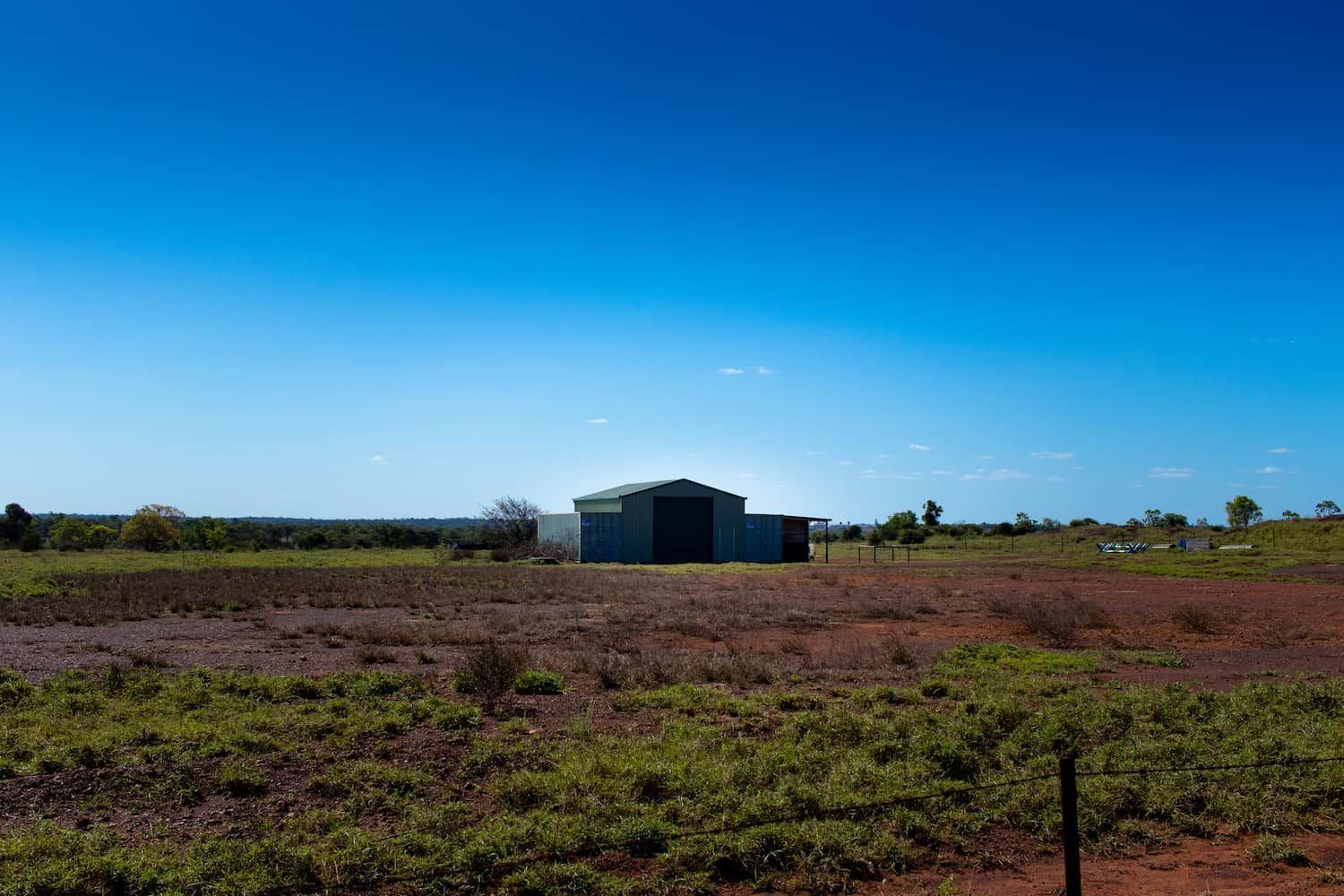 A Large Building In The Middle Of A Field With A Blue Sky In The Background — JTM Projects Australia Pty Ltd in Moranbah, QLD