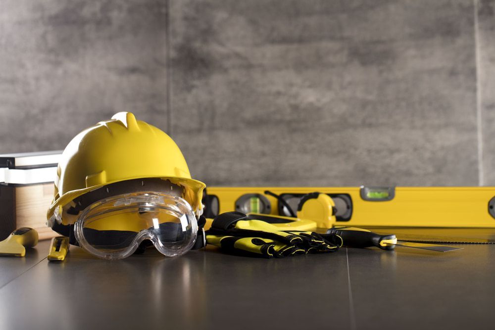 A Hard Hat , Goggles, Gloves, And A Level Are On A Table — JTM Projects Australia Pty Ltd in Hollywell, QLD