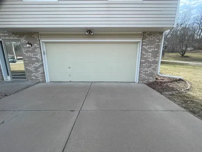 Garage with a concrete driveway in front of a house.