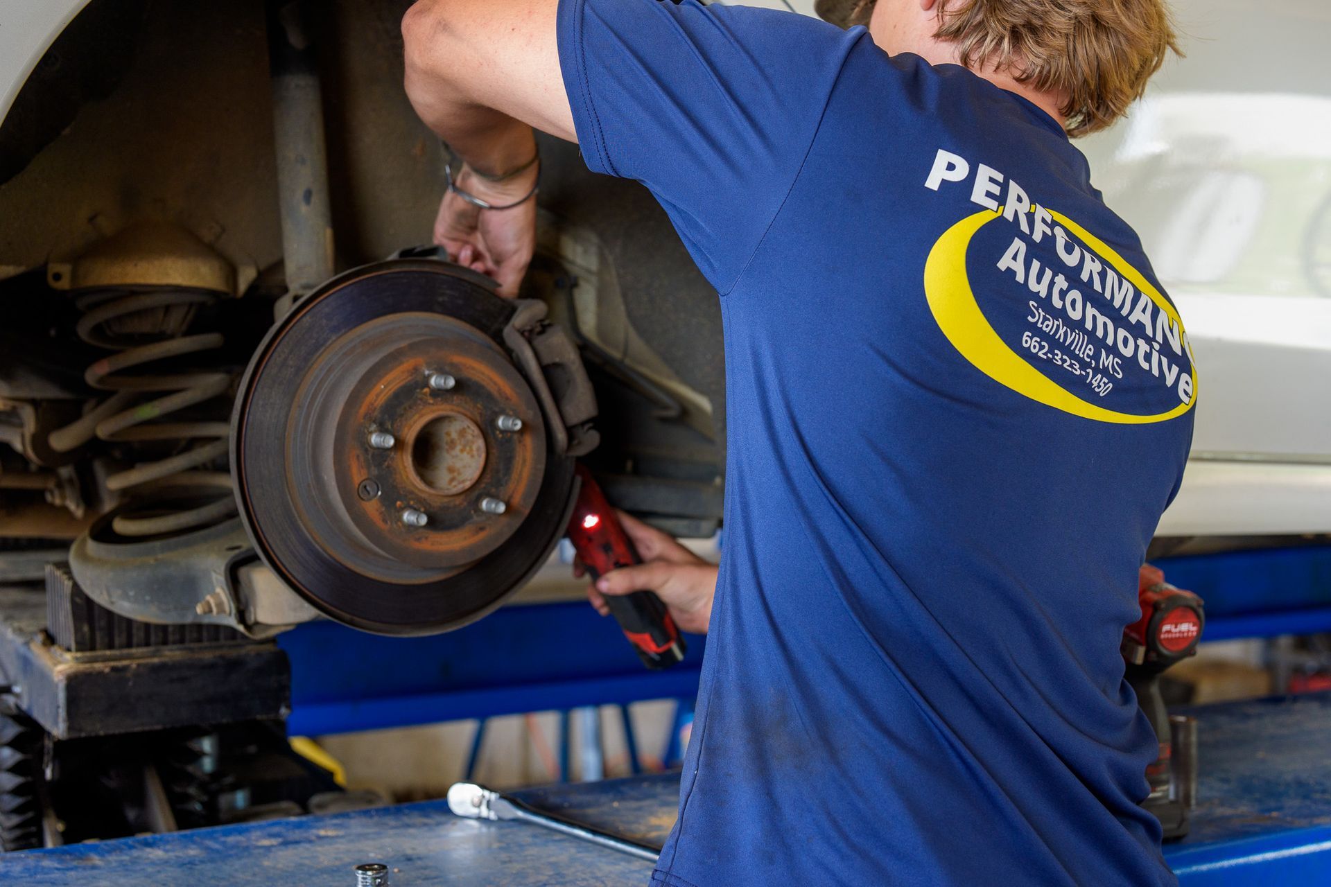 Technician performing a brake inspection with wheel removed