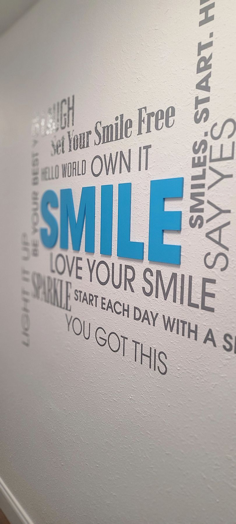 A wall with a quote on it that says `` smile love your smile ''.