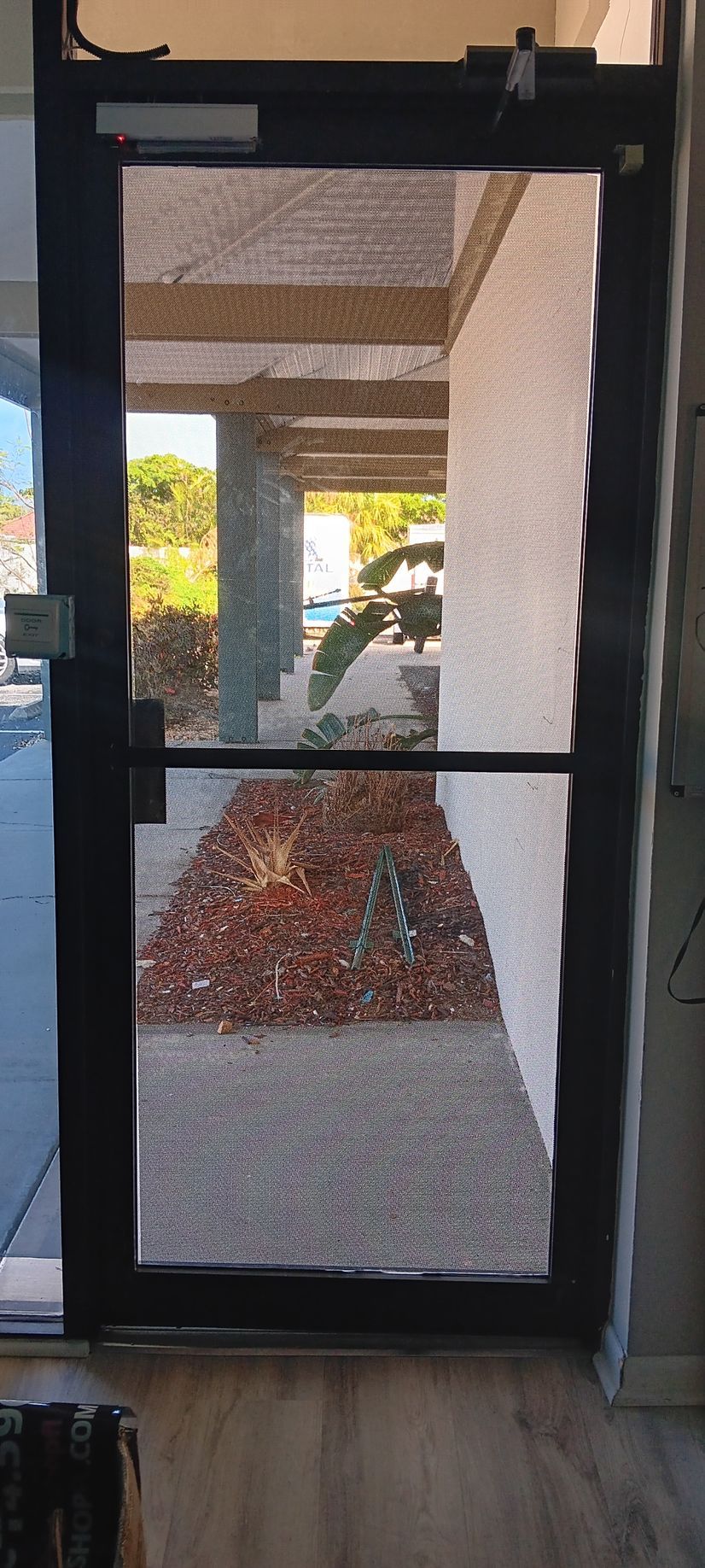 A glass door is open to a sidewalk in a building.