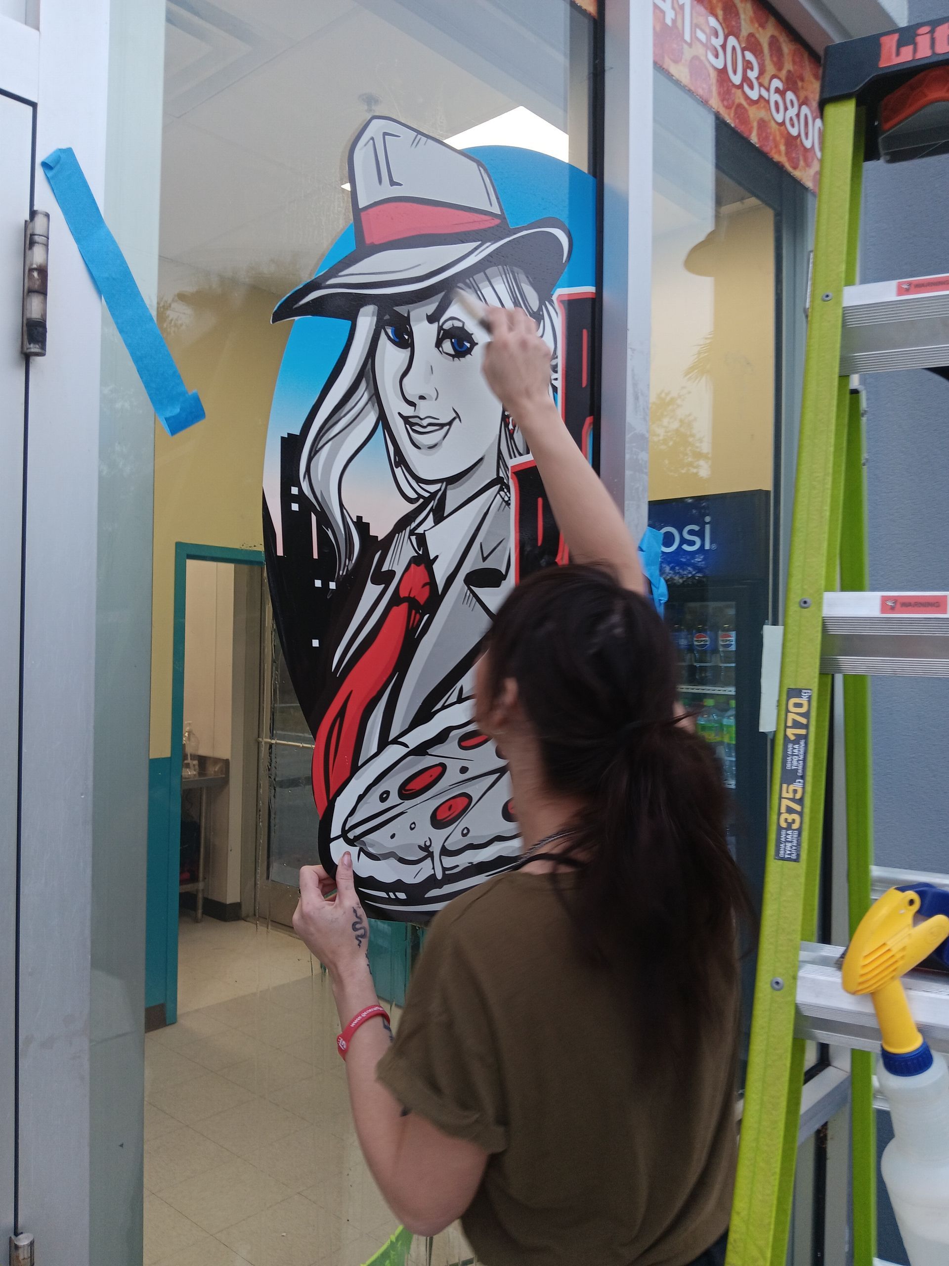A woman is painting a picture of a woman on a window
