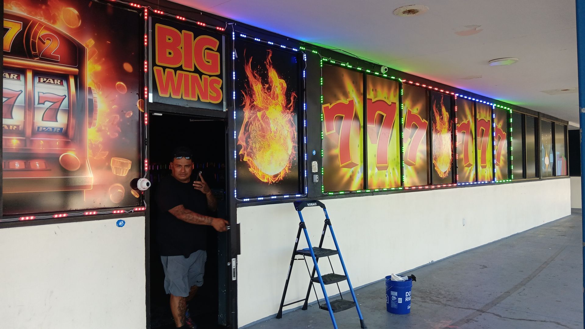 A man is standing in front of a sign that says big win