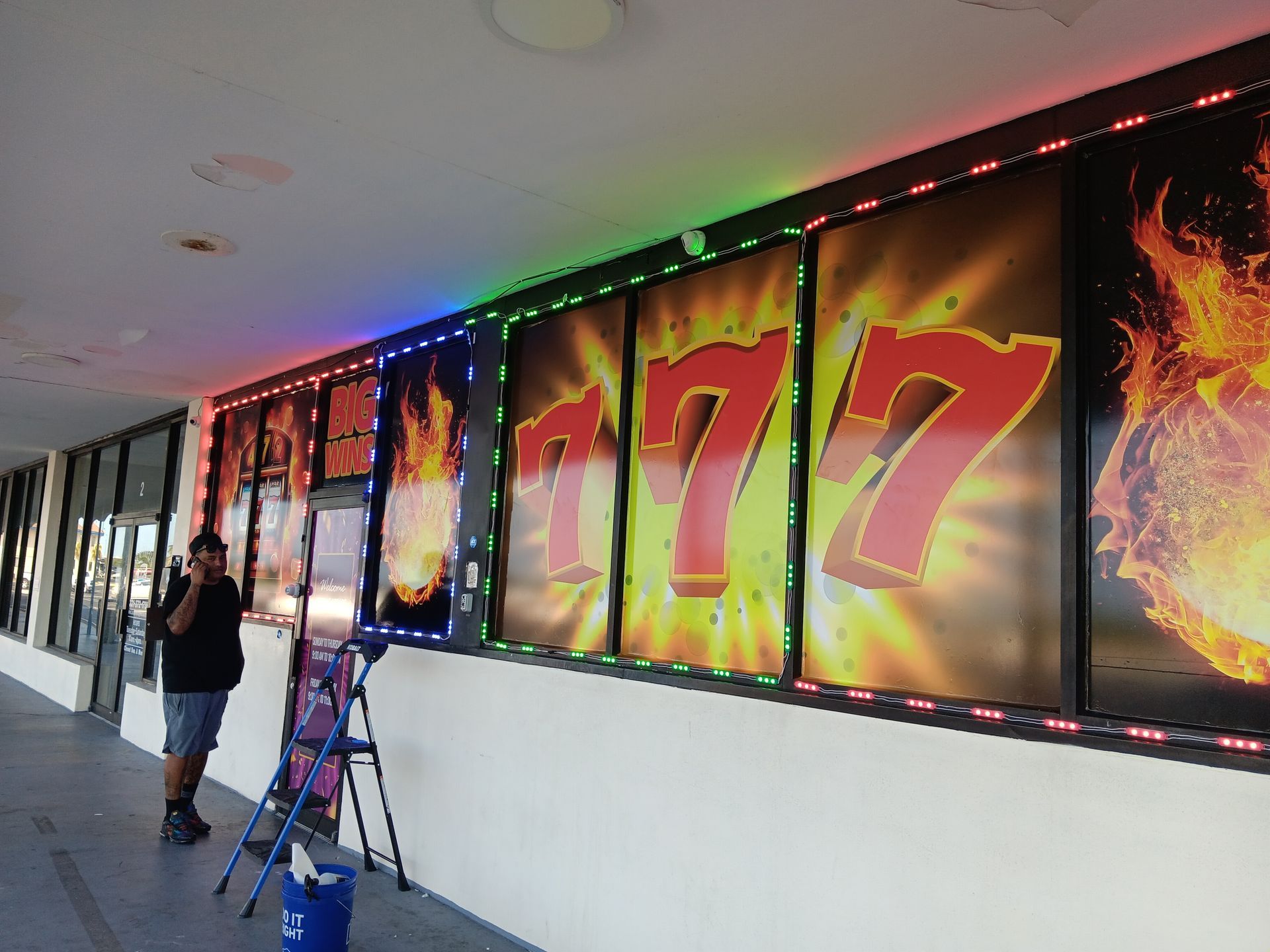 A man is standing in front of a sign that says 777