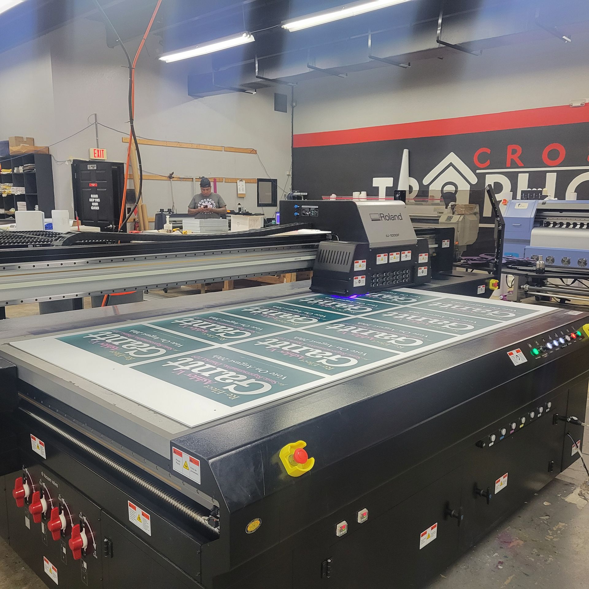 A large printing machine is in a room with a sign that says ' cro ' on it