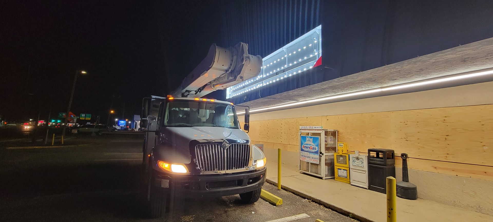 A truck is parked in front of a building at night.
