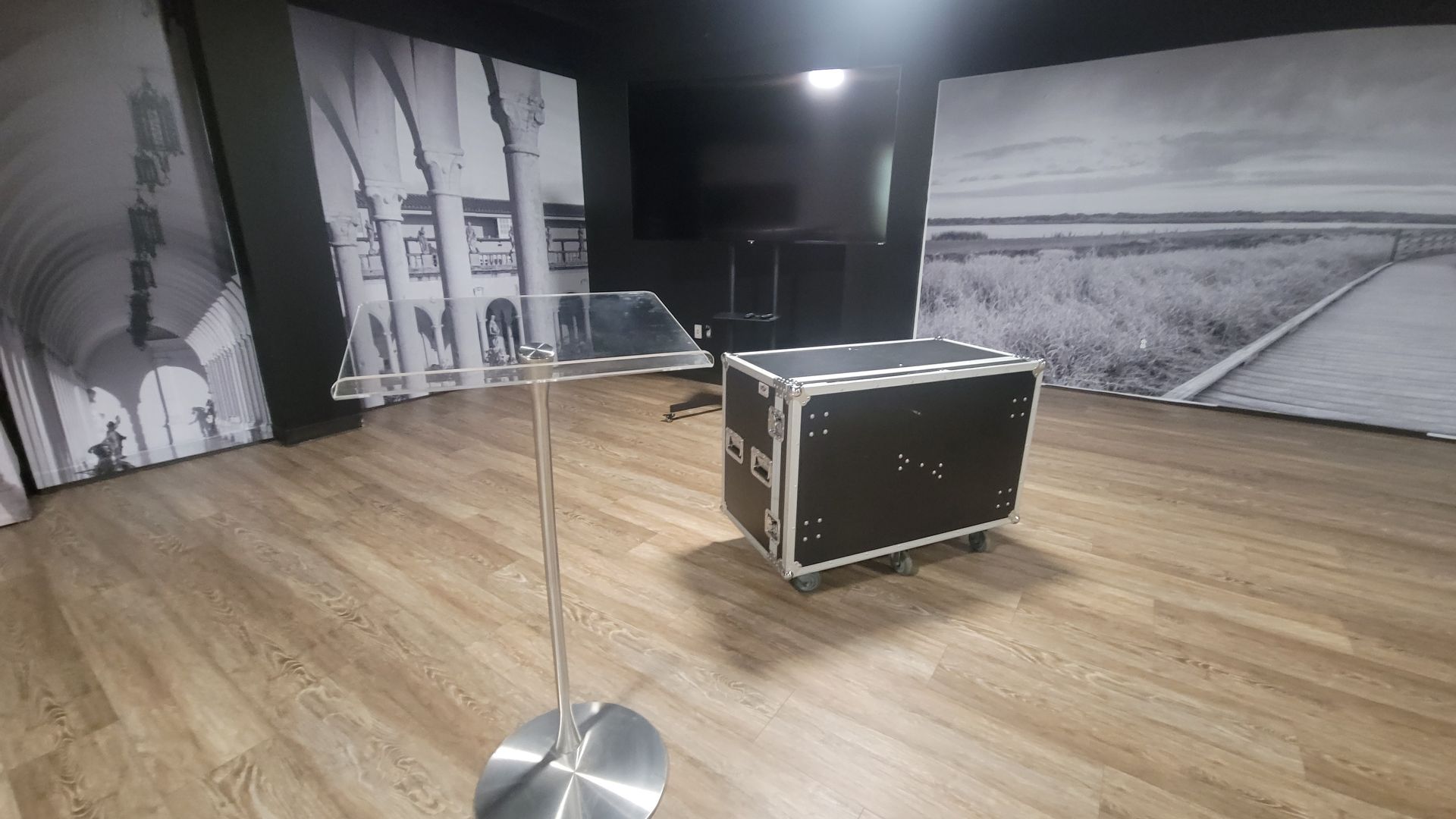 A room with a wooden floor and a podium in the middle of it.