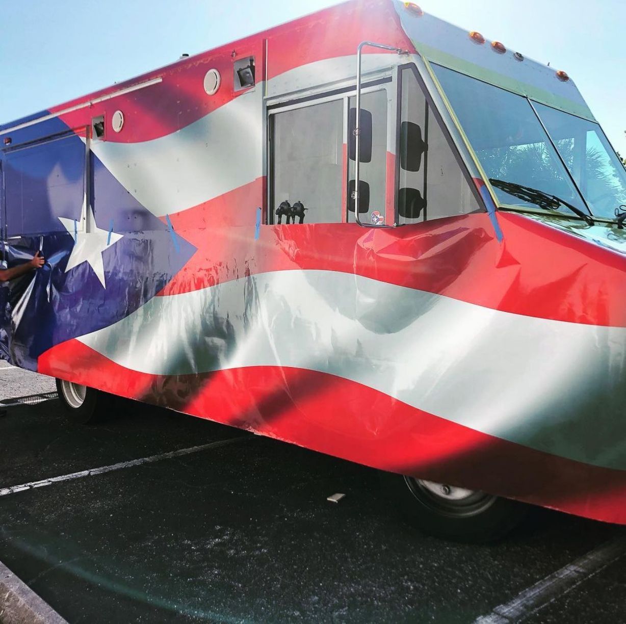 A red white and blue bus with an american flag painted on it