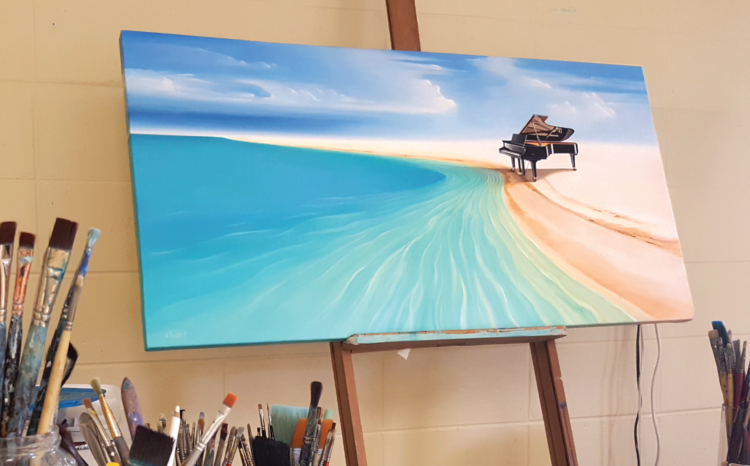 A painting of a piano on a beach on an easel