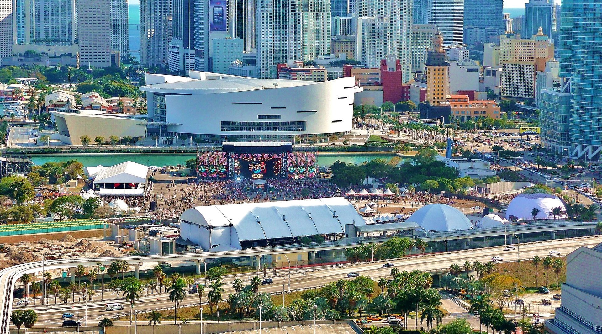 An aerial view of a city with a large white building in the middle