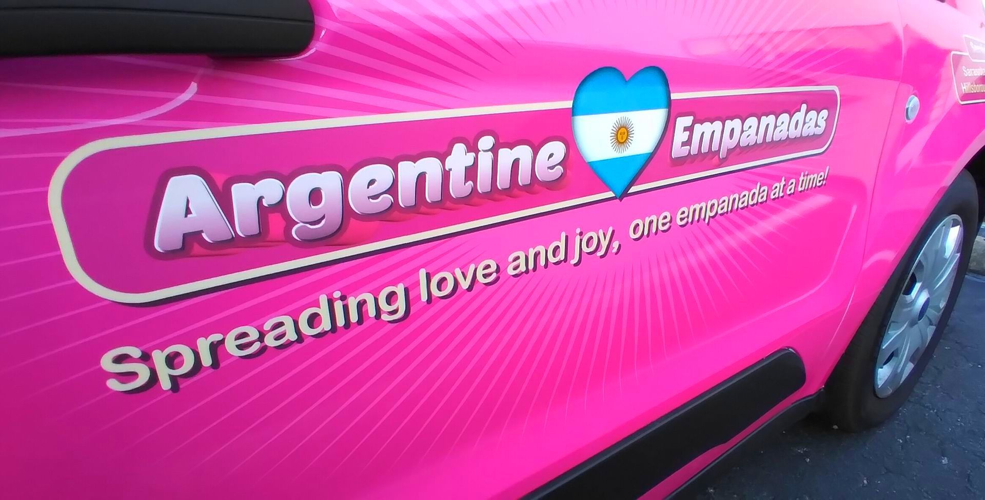 A pink car with argentina empanadas spreading love and joy