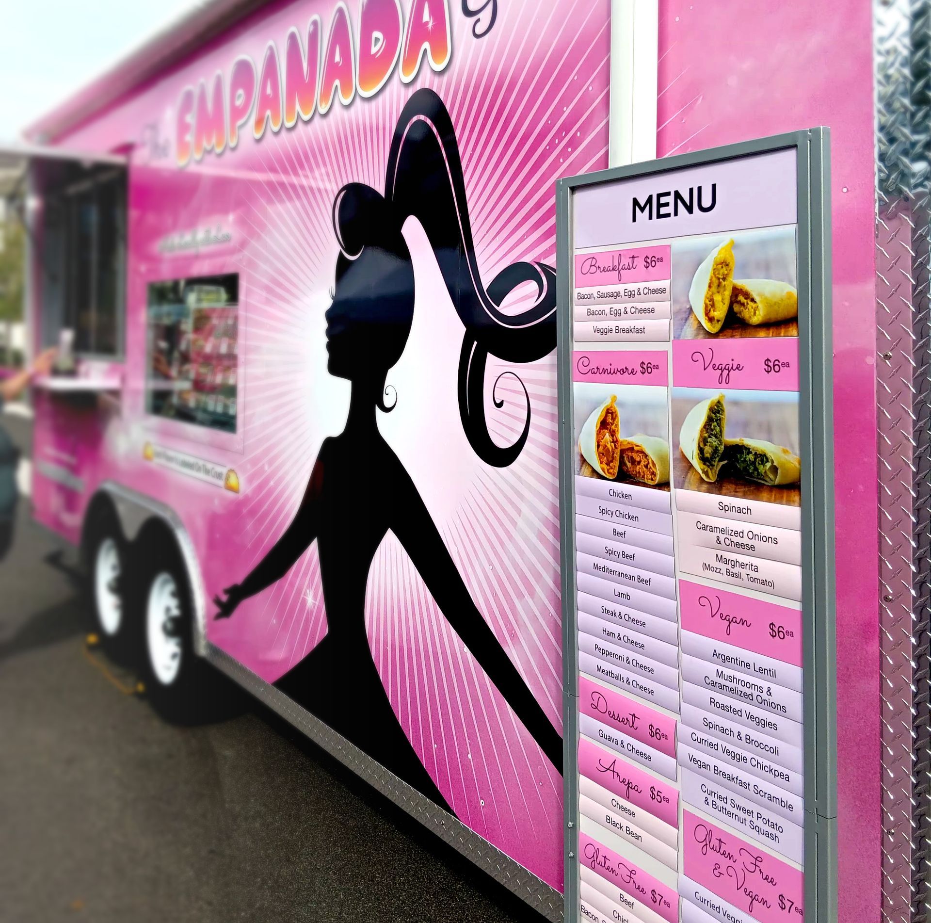 A pink food truck with a menu on the side