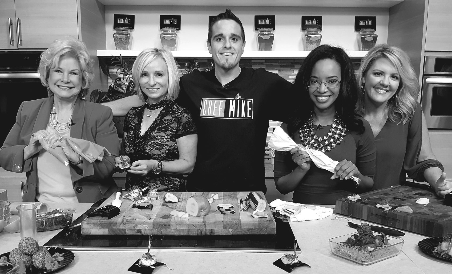 A group of people are posing for a picture in a kitchen.