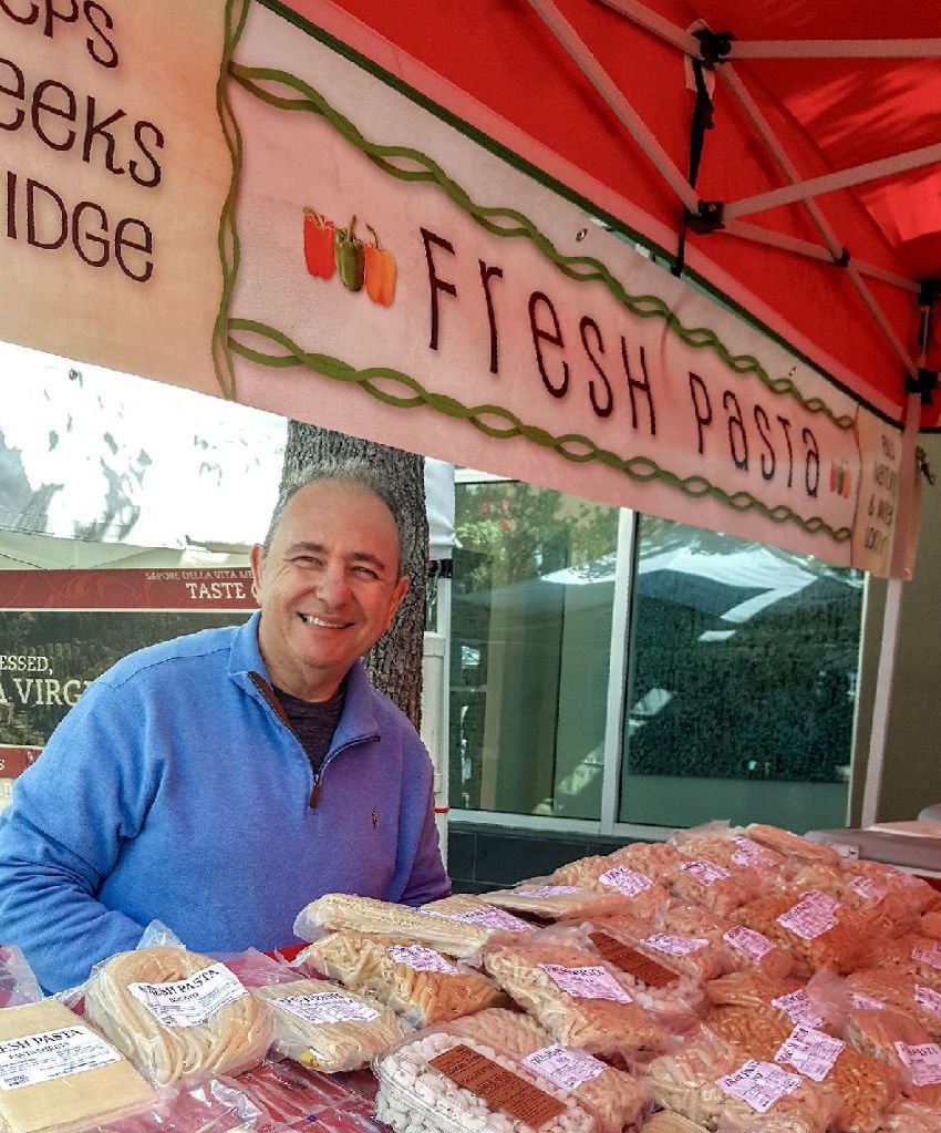 A man stands under a sign that says fresh protein