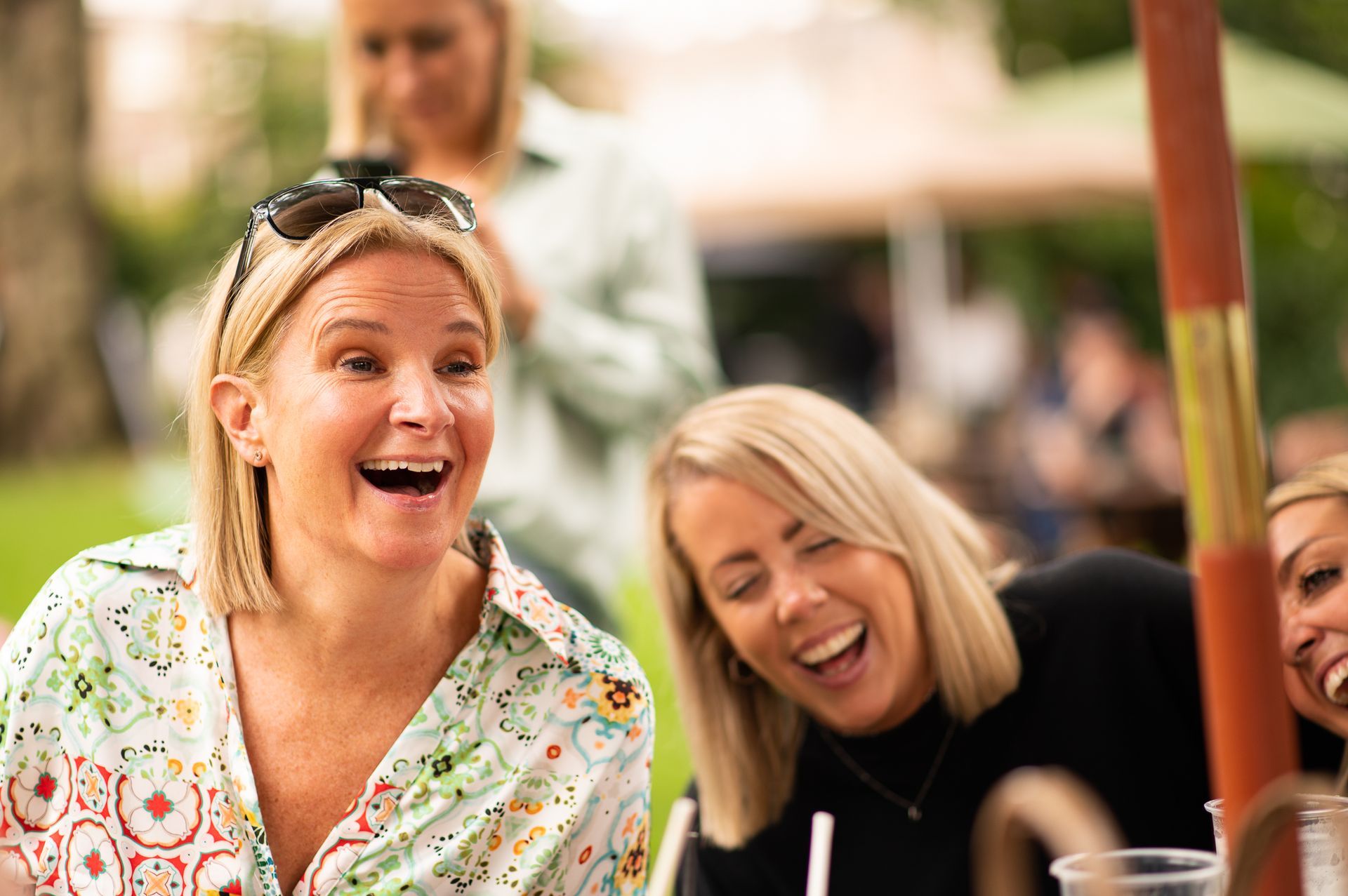 A group of women are sitting at a table laughing.