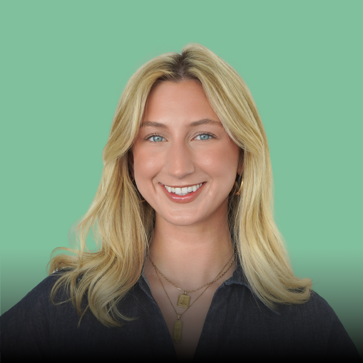 A woman with blonde hair is smiling and wearing a black shirt