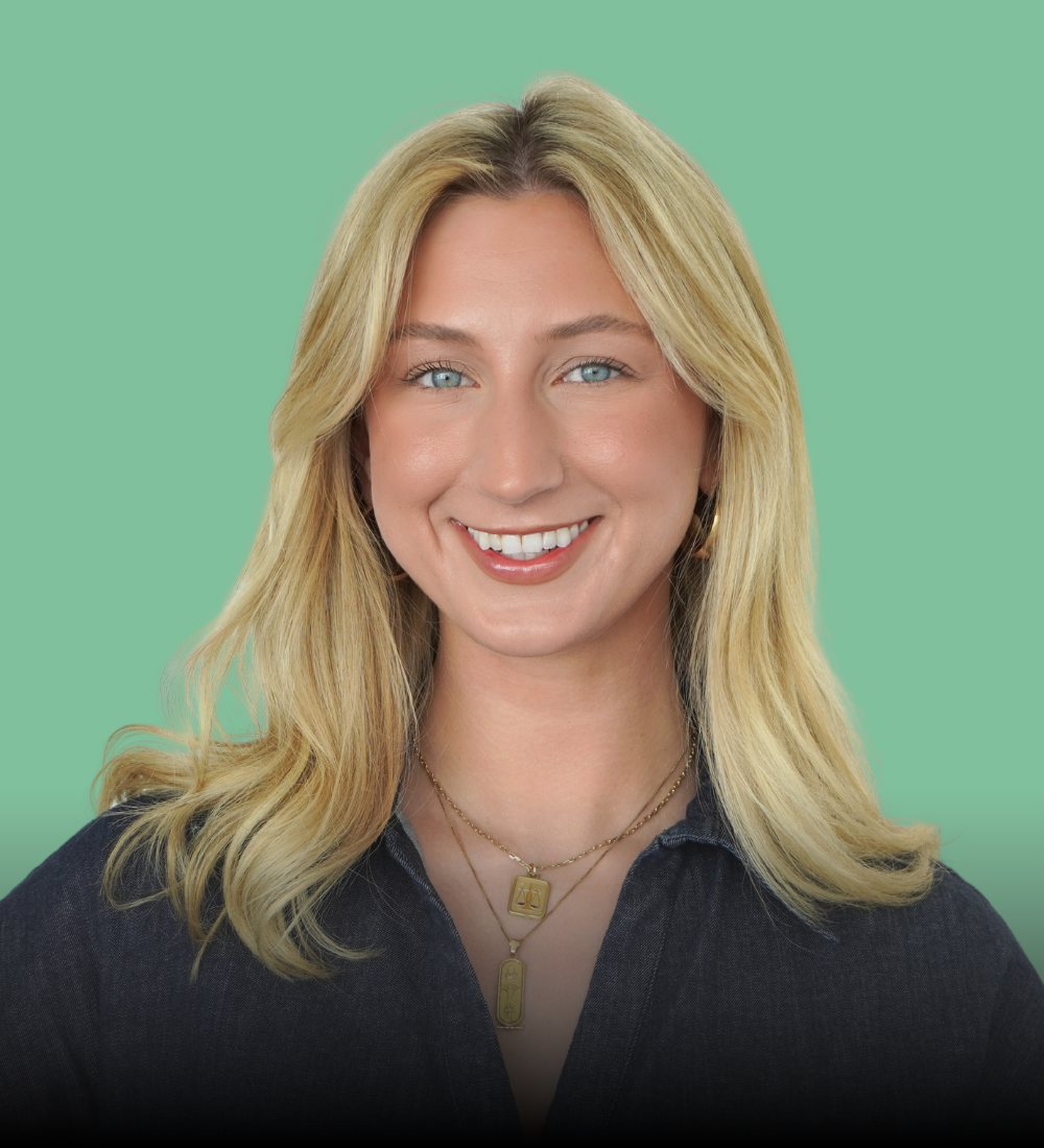 A woman with blonde hair is smiling and wearing a black shirt