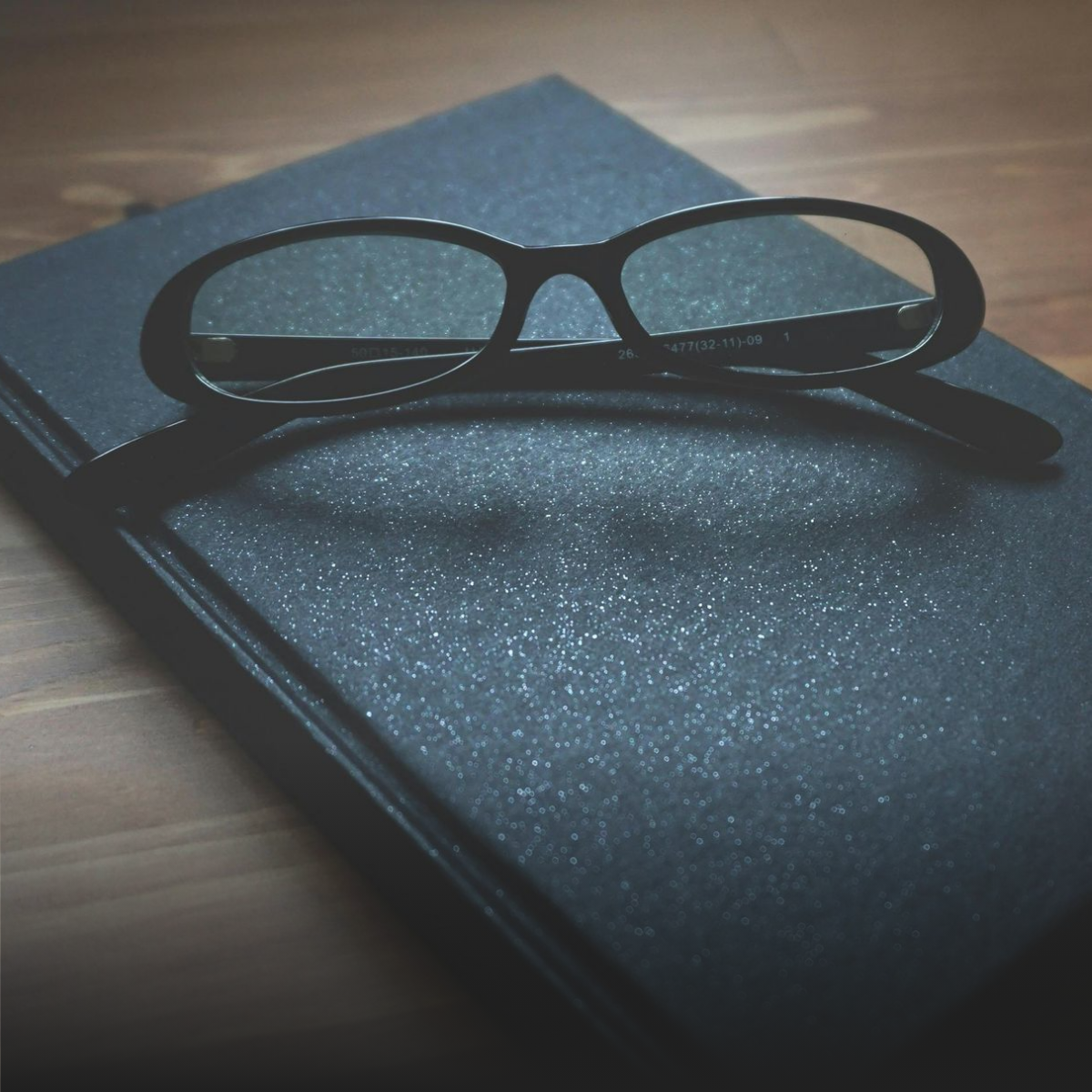 A group of people are sitting around a table shaking hands.