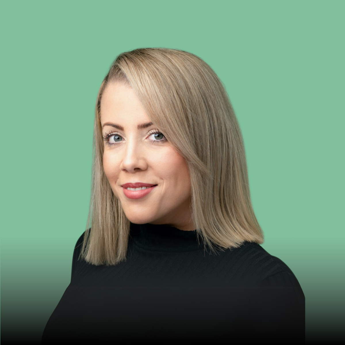 A woman with blonde hair is wearing a black turtleneck and smiling.