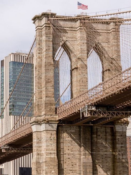 A bridge with a flag on top of it and a building in the background.