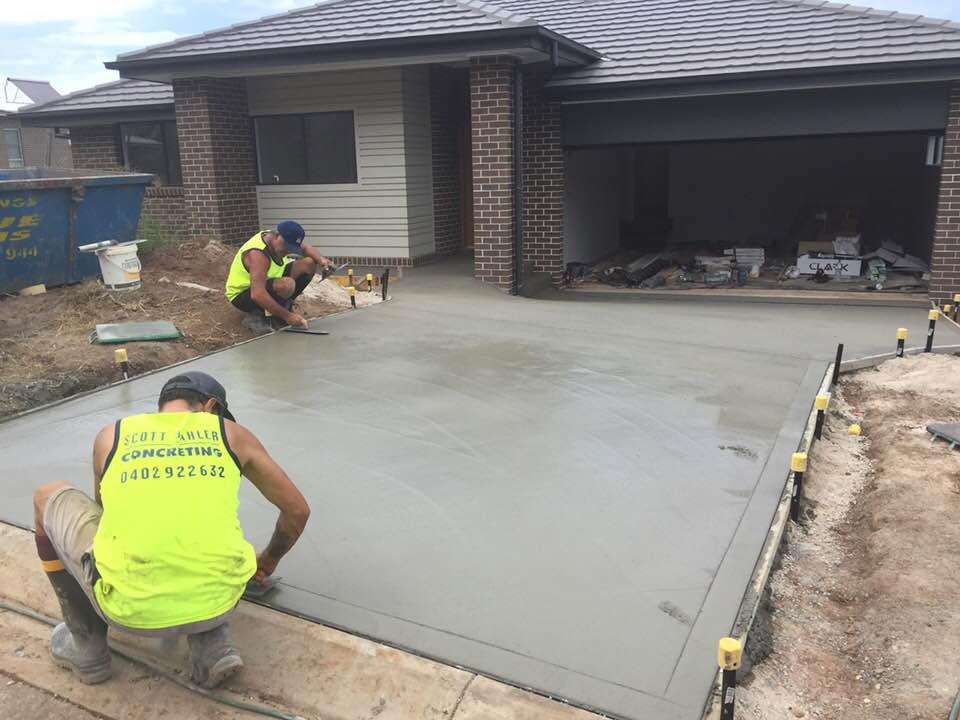 Two Men Leveling Concrete Driveway — Concreters in Port Macquarie, NSW