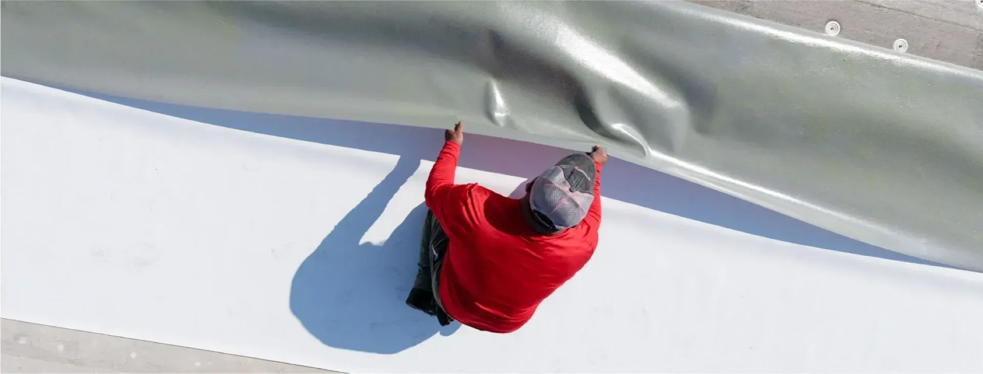 A person in a red jacket is sliding down a snow covered slope.