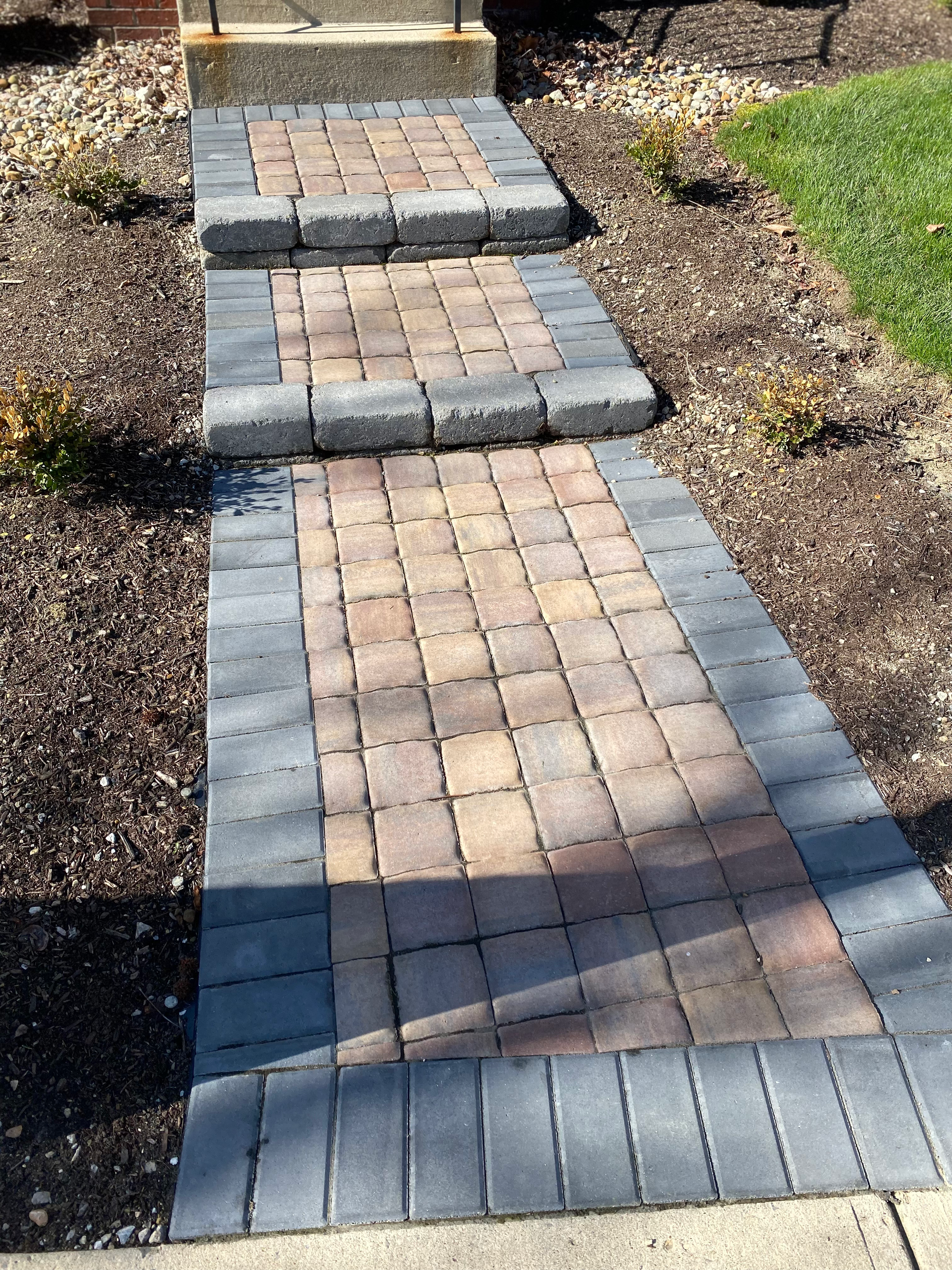 A brick walkway with steps leading to a house