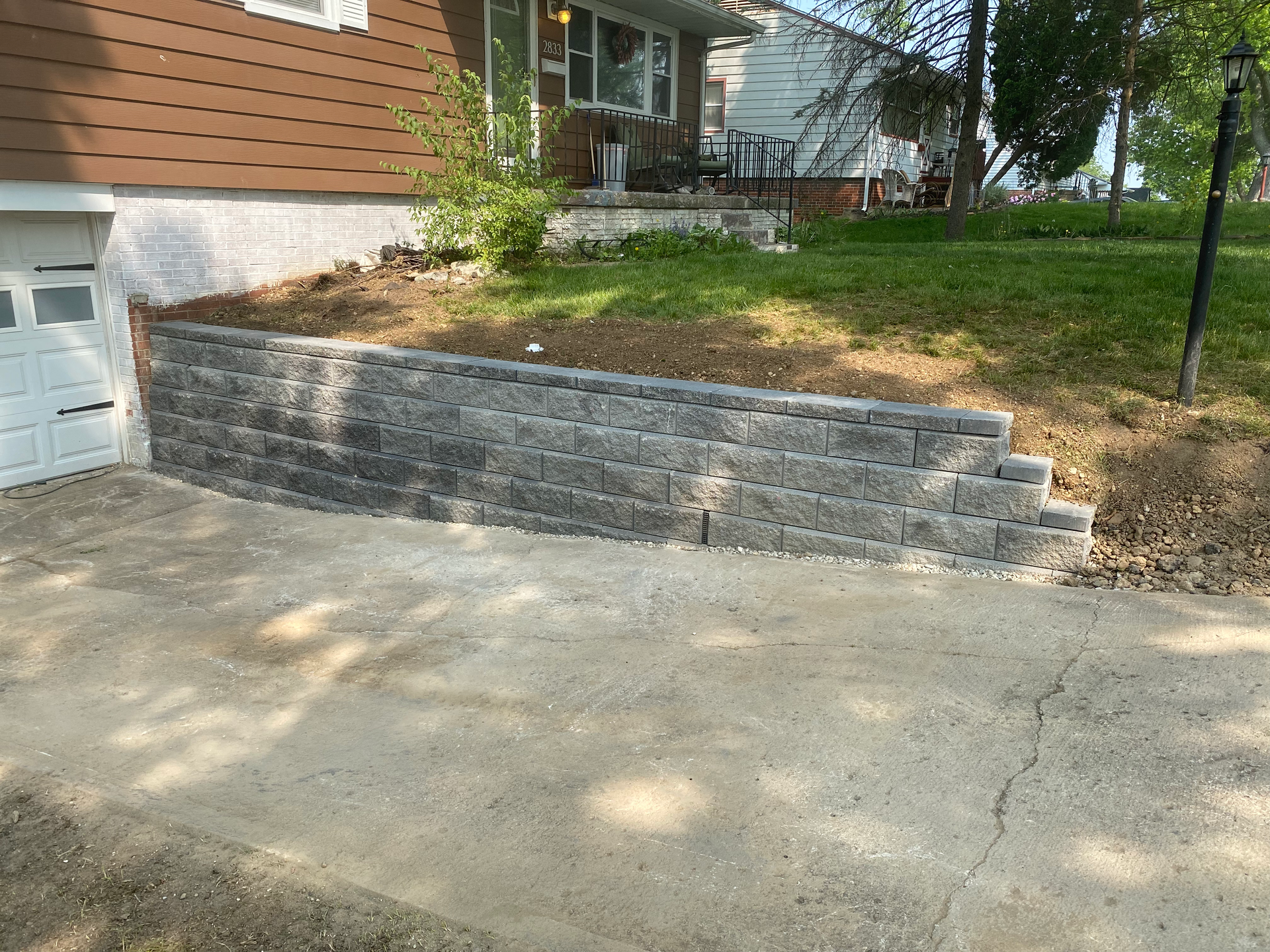 A brick wall is being built in front of a house.