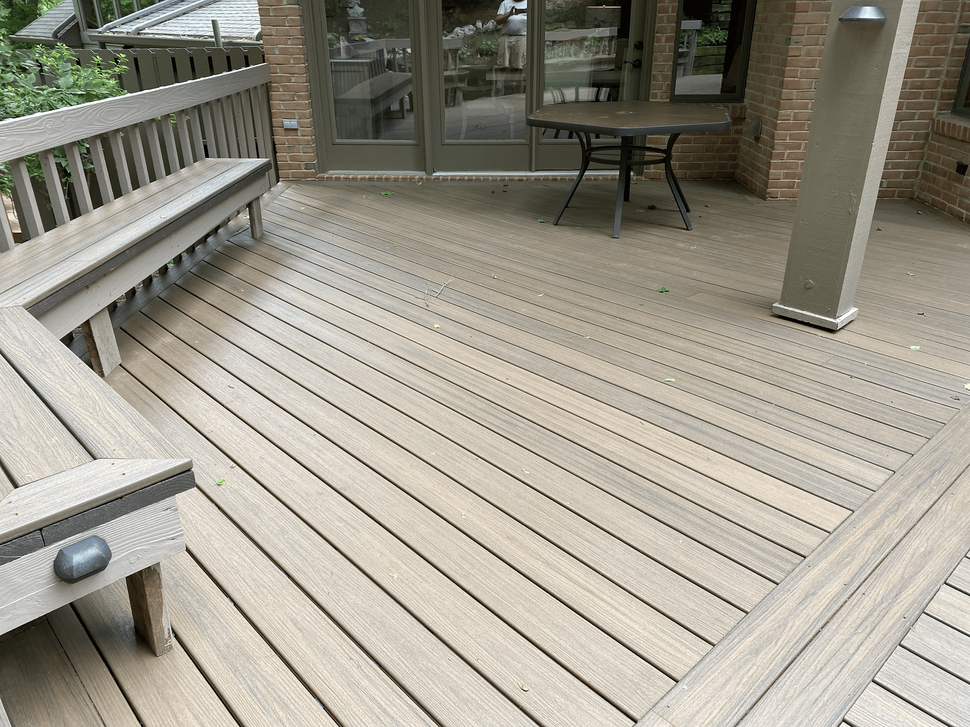 A wooden deck with a bench and a table on it.