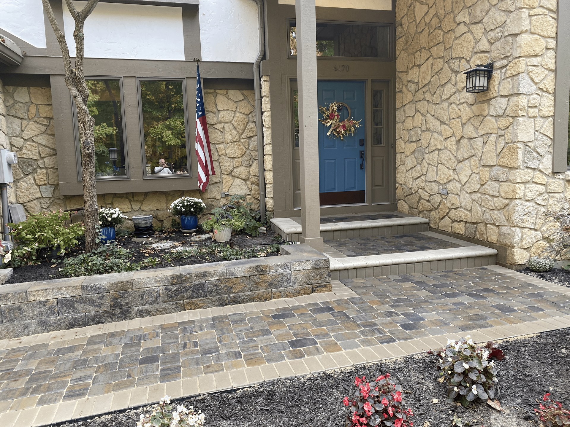 A stone house with a blue door and a walkway in front of it.