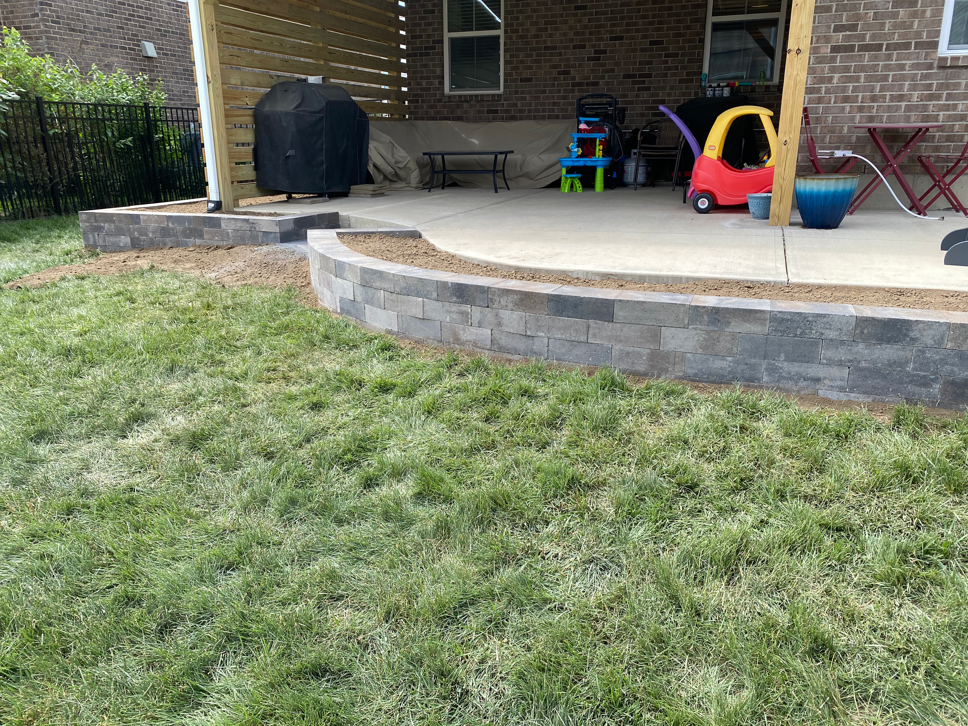 A brick house with a patio and a brick wall in the backyard.