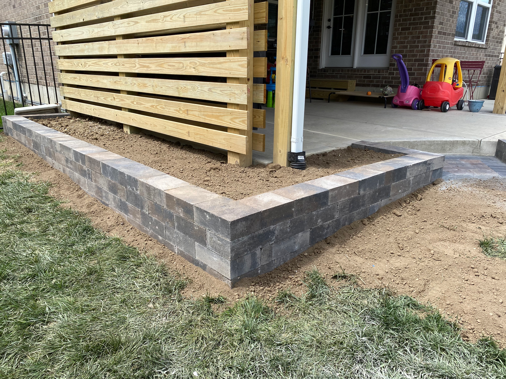 A brick wall is being built in front of a house.