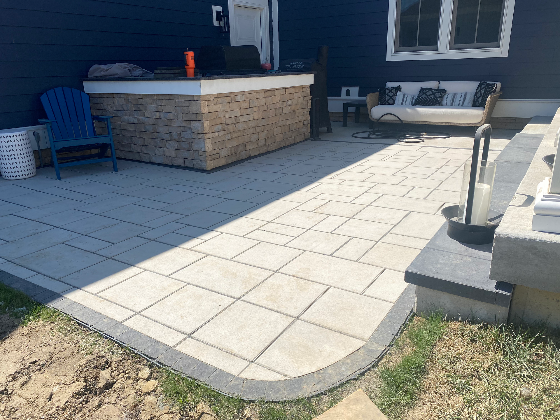 A patio with a hot tub and a couch in the backyard of a house.