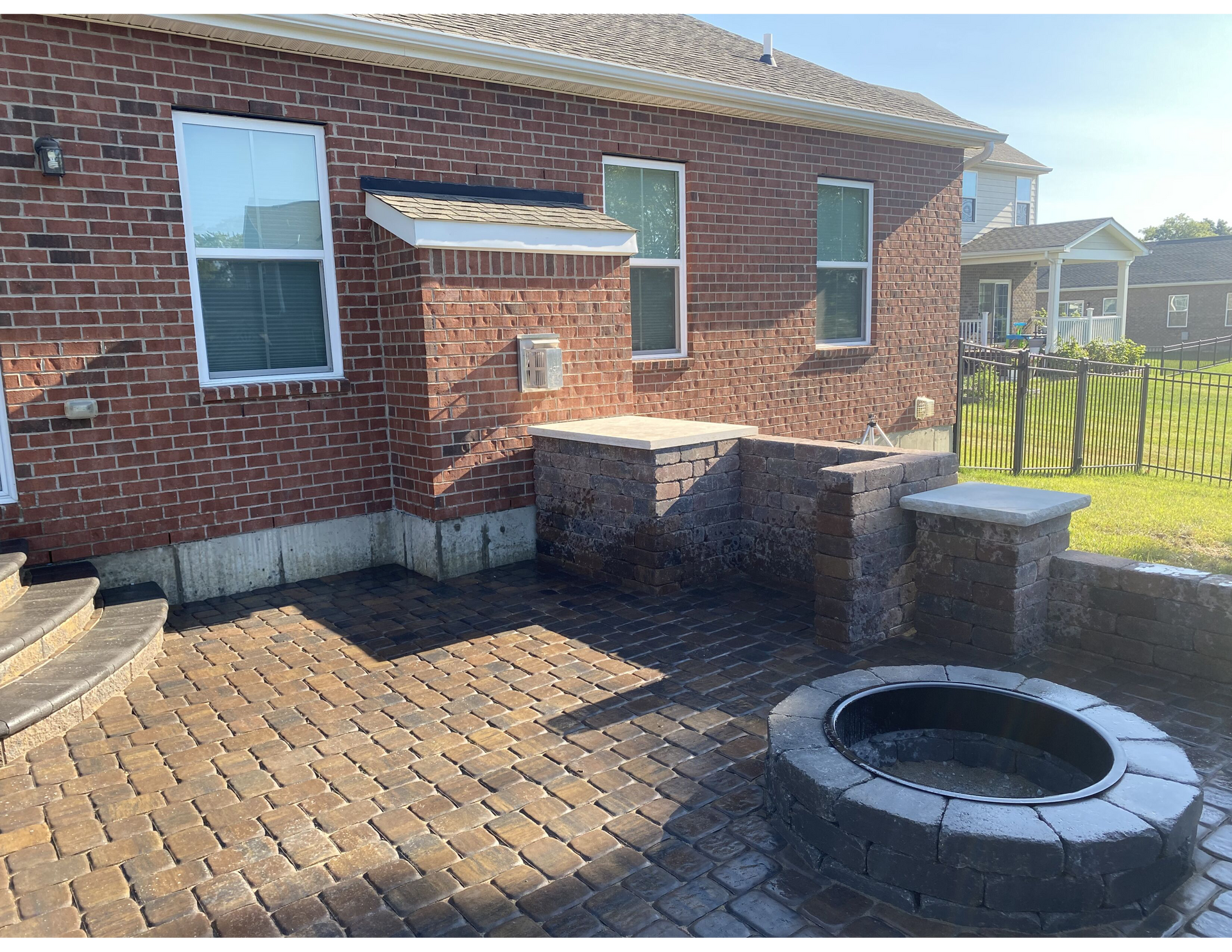 A brick house with a fire pit in front of it.