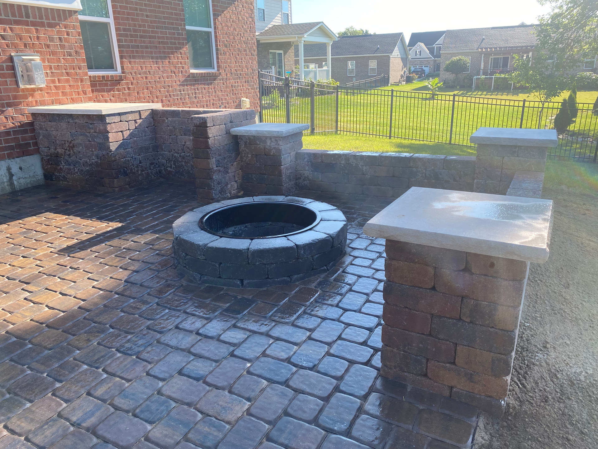 A fire pit is sitting on top of a brick patio.
