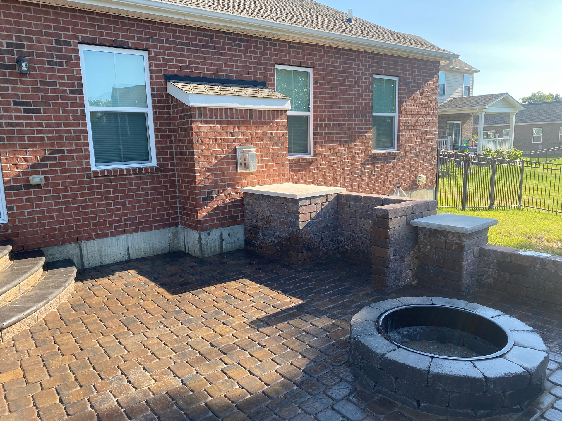 A brick house with a fire pit in front of it.