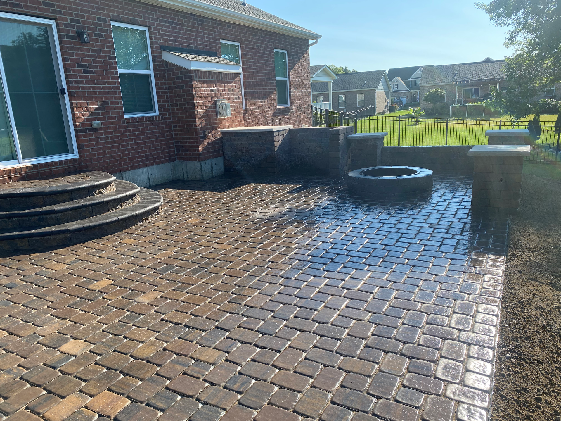 A brick house with a patio and a fire pit in front of it.