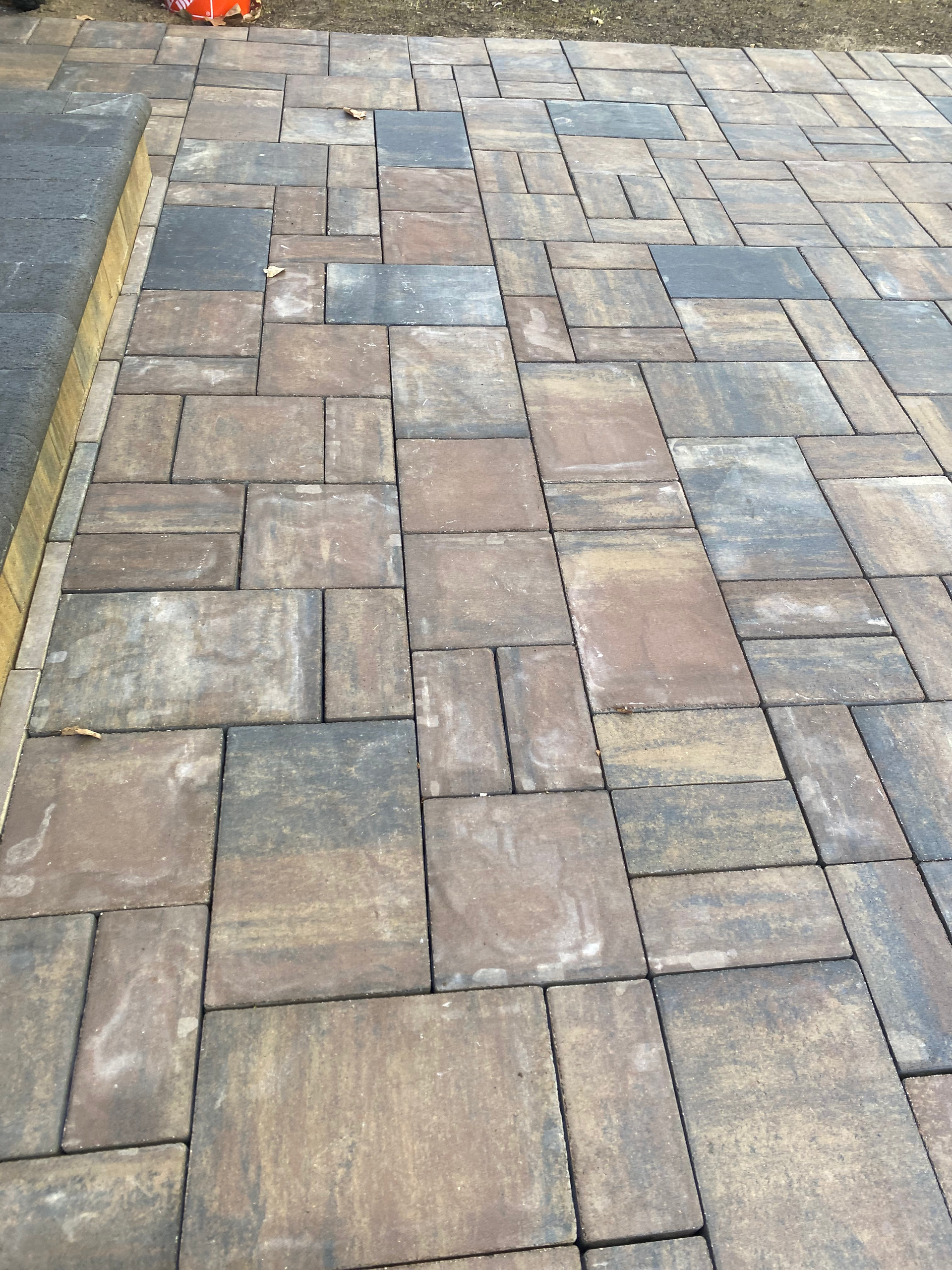 A close up of a brick walkway with a yellow curb.