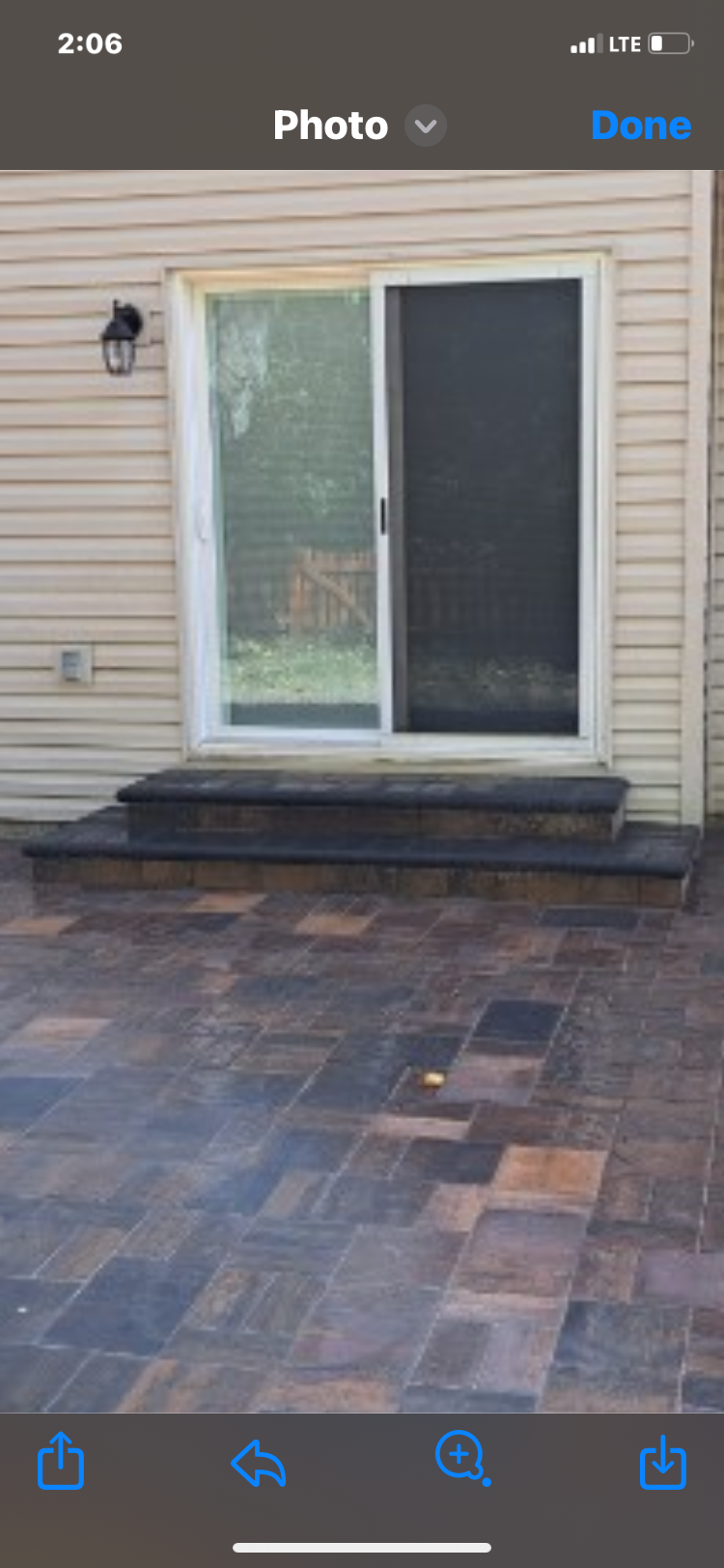 A phone screen shows a picture of a patio with a sliding glass door.