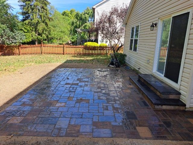 A house with a brick patio in front of it.