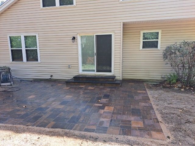 A house with a patio in front of it and a sliding glass door.