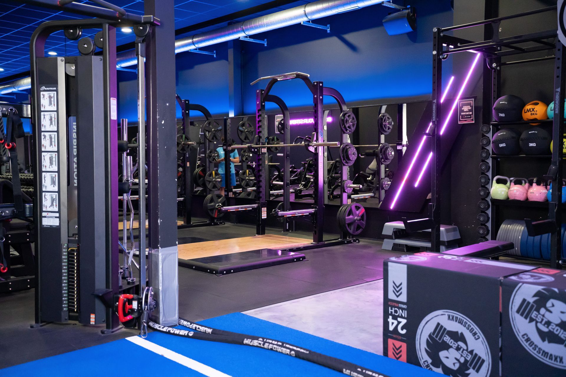 Een sportschool met een neonreclame waarop staat: 'Tijd om te trainen'.