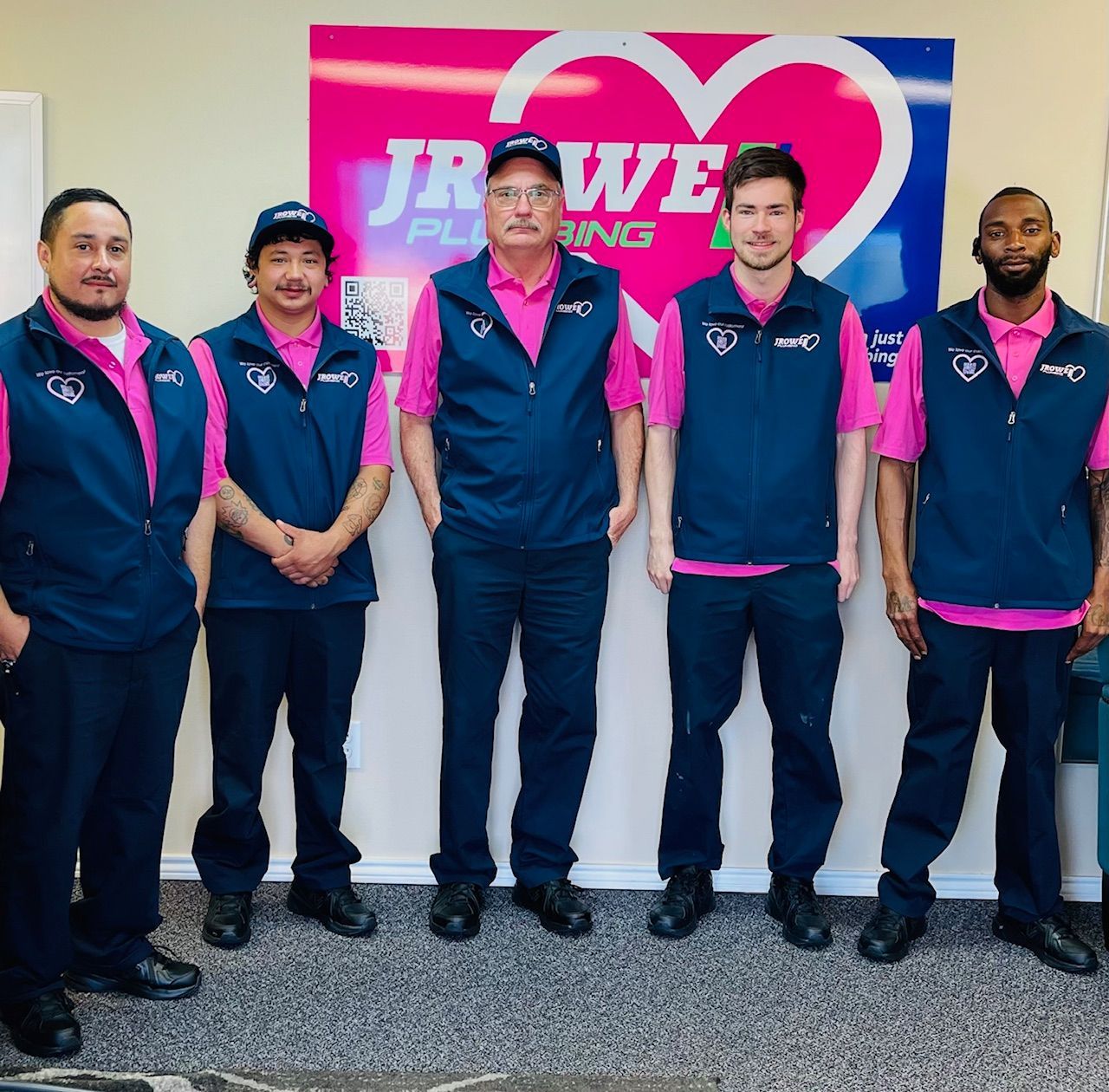 A group of men standing in front of a sign that says jr we