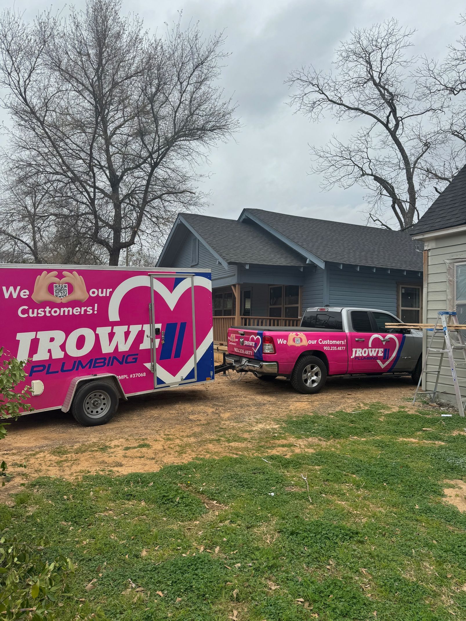 Two trucks are parked in front of a house.