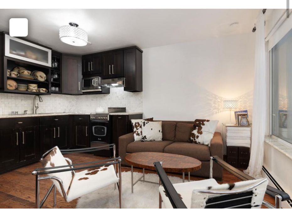 Living room with white sofa, brown coffee table, and window.