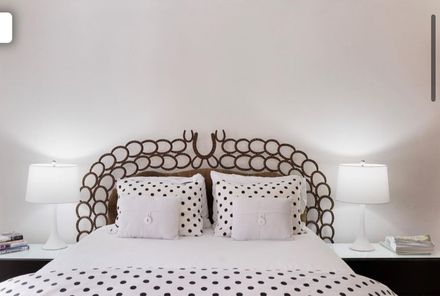 Studio apartment with bed, sofa, kitchen, and large windows.